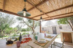 un comedor al aire libre con una mesa con comida en TD Trulli Amabilia Design Luxury Trulli with Pool, en Ostuni 48 fotos más