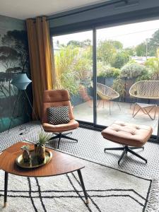 a living room with a chair and a table at La Sodilie proche centre ville au calme Parking public gratuit in Nantes +13 photos