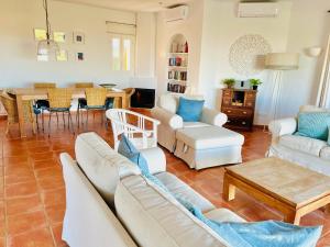 a living room with white furniture and a table at Finca la Vina in Vejer de la Frontera