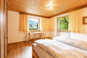 Un dormitorio con una cama y una mesa y una ventana. en Haus Weinberg, en Pettneu am Arlberg