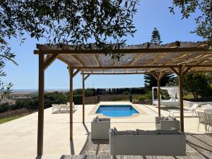 a pergola and a swimming pool in a yard at Finca la Vina in Vejer de la Frontera