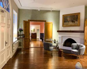 a living room with a fireplace and two chairs at Ferienvilla Jagdschloss Friedrichsmoor in Neustadt-Glewe