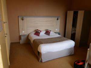 ein Schlafzimmer mit einem großen weißen Bett mit zwei Kissen in der Unterkunft Logis Hôtel Le Lion d'Or in Chauvigny