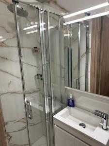 a bathroom with a shower and a sink and a mirror at Votsala in Loutraki +13 photos