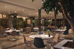 a restaurant with tables and chairs and trees at Hotel Excelsior in Marina di Massa