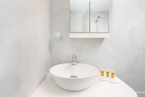 a white bathroom with a sink and a mirror at santairini in Vourvoulos