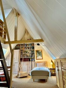 a attic bedroom with a bed and a book shelf at Logis Saint-Flaceau in Le Mans