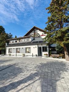 a white building with a tree in front of it at Willa Rybacka in Krynica Morska