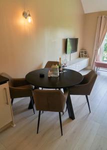 a living room with a table and chairs and a tv at Spacious Two Bedroom Hideaway in Wokingham with En Suite, Free Wi Fi and Parking, Sleeps Four in Wokingham