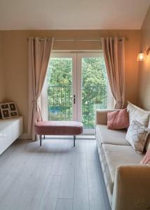 a living room with a couch and a large window at Spacious Two Bedroom Hideaway in Wokingham with En Suite, Free Wi Fi and Parking, Sleeps Four in Wokingham