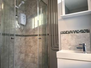a bathroom with a shower and a sink at Samuel Place by SG of Crewe - 5 Beds, 4 Bedrooms, 2 Bath in Crewe +16 photos