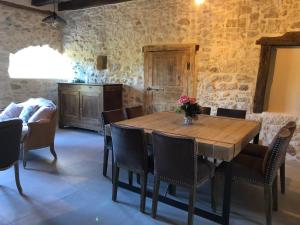 a dining room with a wooden table and chairs at Le Gîte de Marie in Saint-Front-la-Rivière