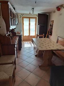 a living room with a table and a kitchen at Appartamento Uso Turistico Entracque in Entracque