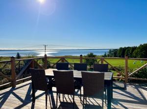 a table and chairs on a deck with a view of the ocean at The Gardeners House, Lake View & Sauna in Vreta Kloster