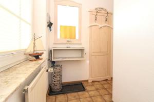 a kitchen with a door and a window and a shelf at Deichbrise in Greetsiel +10 photos