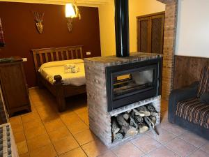 a living room with a fireplace and a bed at La Casita Roja Del Arcoíris in Riópar