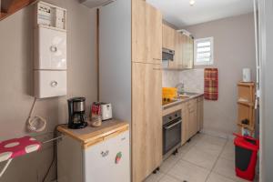 a small kitchen with a refrigerator and a sink at Villa Muscade - Maison avec piscine partagée in Saint-François