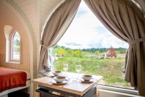 a bedroom with a table with wine glasses and a window at Les Nuits de Thoiry in Thoiry