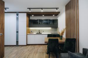 a kitchen with a table and chairs and a counter at DUGA PARK lux in Kragujevac