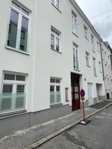 ein weißes Gebäude mit einer roten Tür auf einer Straße in der Unterkunft Apartment Wien in Wien
