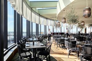 a restaurant with tables and chairs and large windows at Crystalbrook Kingsley in Newcastle