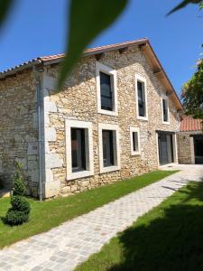 Gîte Chez Marcel & Marthe في Saint-Front-la-Rivière: منزل حجري مع مسار أمامه