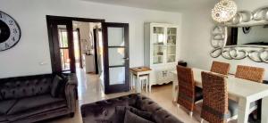 a living room with a couch and a clock on the wall at Casa Sol Corralejo in Corralejo