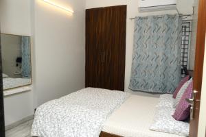 a small bedroom with a bed and a mirror at Downtown Residency in Chennai