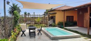 un cortile con piscina, sedie e una casa di Vila Corumbau Cacau a Corumbau