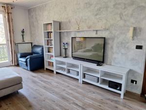 a living room with a television on a white entertainment center at Alloggio Gravere in Gravere