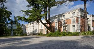 een lege straat voor een wit gebouw bij Waldorf Astoria Versailles - Trianon Palace in Versailles +105 foto's