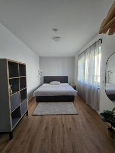 a bedroom with a bed and a wooden floor at Deluxe Ferienwohnung am Rande des Pfälzer Waldes in Schwedelbach