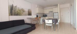 a living room with a couch and a table and chairs at Olivia Sunset Playa in Puerto de Santiago