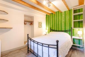 ein Schlafzimmer mit einem Bett und einem grünen Vorhang in der Unterkunft Couleur Patio, Loft Atypique, Sauna in Saint-Denis-dʼOléron