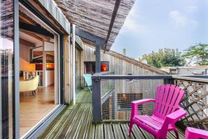 ein rosa Stuhl, der auf dem Balkon eines Hauses steht in der Unterkunft Couleur Patio, Loft Atypique, Sauna in Saint-Denis-dʼOléron
