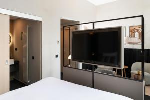 a bedroom with a large flat screen tv at Hotel Keyser Breda in Breda