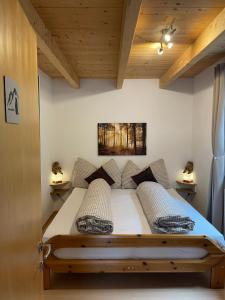 a bedroom with a bed in a room with wooden ceilings at La Trapla in Samnaun