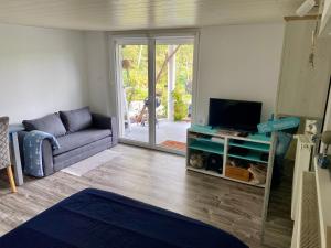 a living room with a couch and a tv at Le Pi'style(chambre,cuisine,salle d’eau,terrasse) in Ingwiller