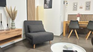 a living room with a chair and a table at Barrierefreie Ferienwohnung in Winterscheid nahe Köln Bonn bis 4 Personen mit Netflix und mehr in Ruppichteroth