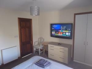 a bedroom with a bed and a tv on the wall at The Heritage Guest House in Montrose