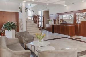 a lobby with chairs and a table and stairs at Hotel i Restauracja Borowianka in Ostrów Wielkopolski