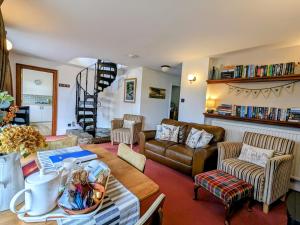 een woonkamer met een tafel en een bank bij Gamekeeper’s Cottage Martinhoe in Martinhoe