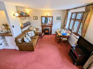 een woonkamer met een bank en een tafel bij Gamekeeper’s Cottage Martinhoe in Martinhoe