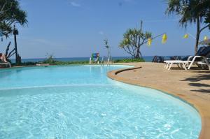 a beach with a pool, chairs, and a pool table at Lanta Nice Beach Resort - SHA Extra Plus in Ko Lanta