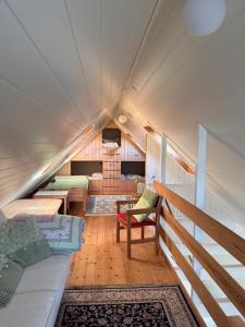 une chambre avec un canapé et des chaises dans une maison dans l'établissement Cottage by the waterfront, à Vestmanna