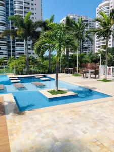 a swimming pool with a palm tree in the middle at Apto na Ilha Pura próximo ao Parque Olímpico da Barra da Tijuca in Rio de Janeiro