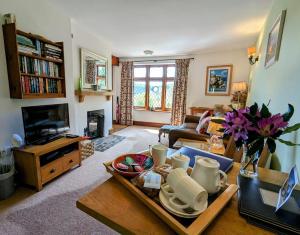 a living room with a couch and a table at Chauffeur’s Cottage Martinhoe in Martinhoe