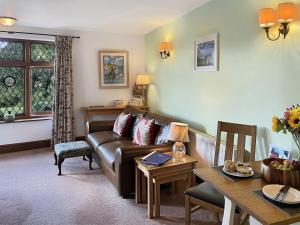 a living room with a couch and a table at Chauffeur’s Cottage Martinhoe in Martinhoe