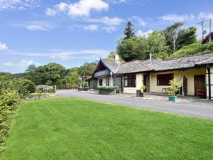 a house with a green lawn in front of it at Chauffeur’s Cottage Martinhoe in Martinhoe
