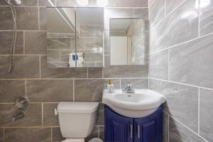 um banheiro com uma pia, um vaso sanitário e um espelho em Fresh Private Apartment Lower level- 2 beds em Brampton